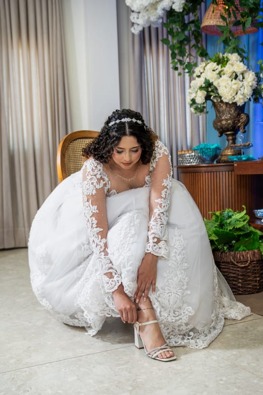 Noiva já de vestido afivelando a sandália