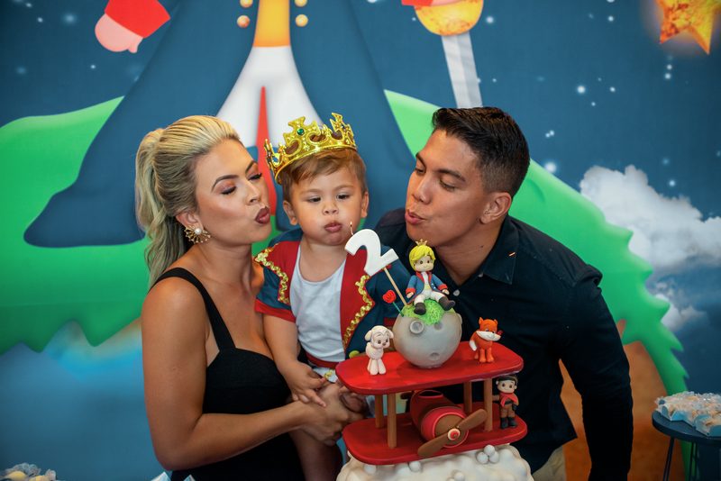 Família reunida na mesa do bolo de um aniversário infantil