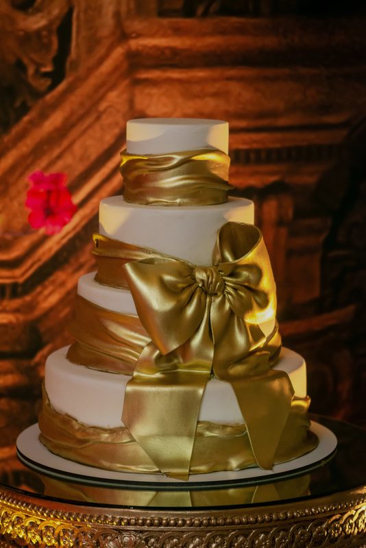 Bolo branco e dourado com laço de cetim